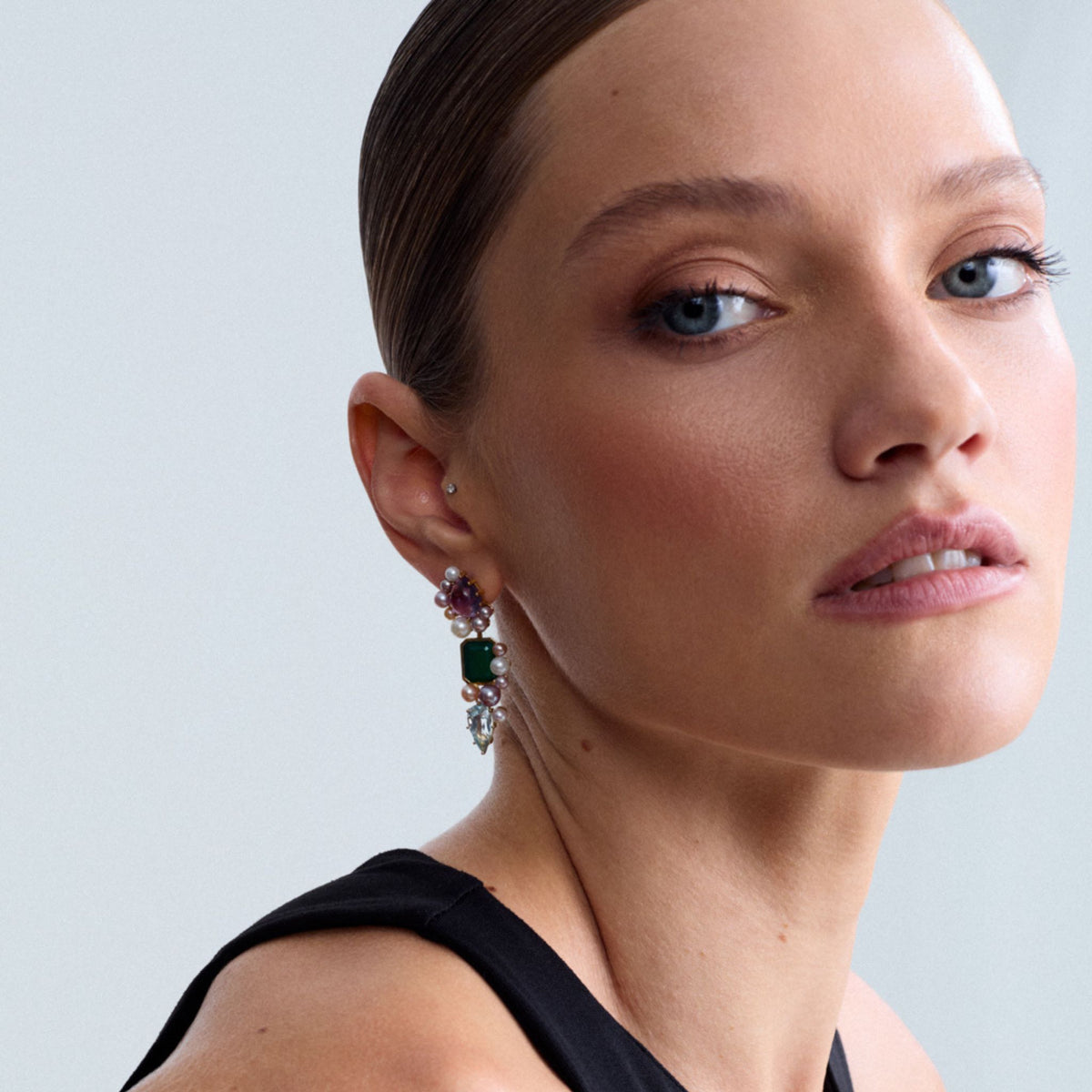 Editorial portrait of a model wearing the Artemisia Cascade Mini Earrings in 18K gold-plated sterling silver featuring multicolored freshwater cultured pearls, genuine green agate, genuine amethyst and genuine blue topaz.