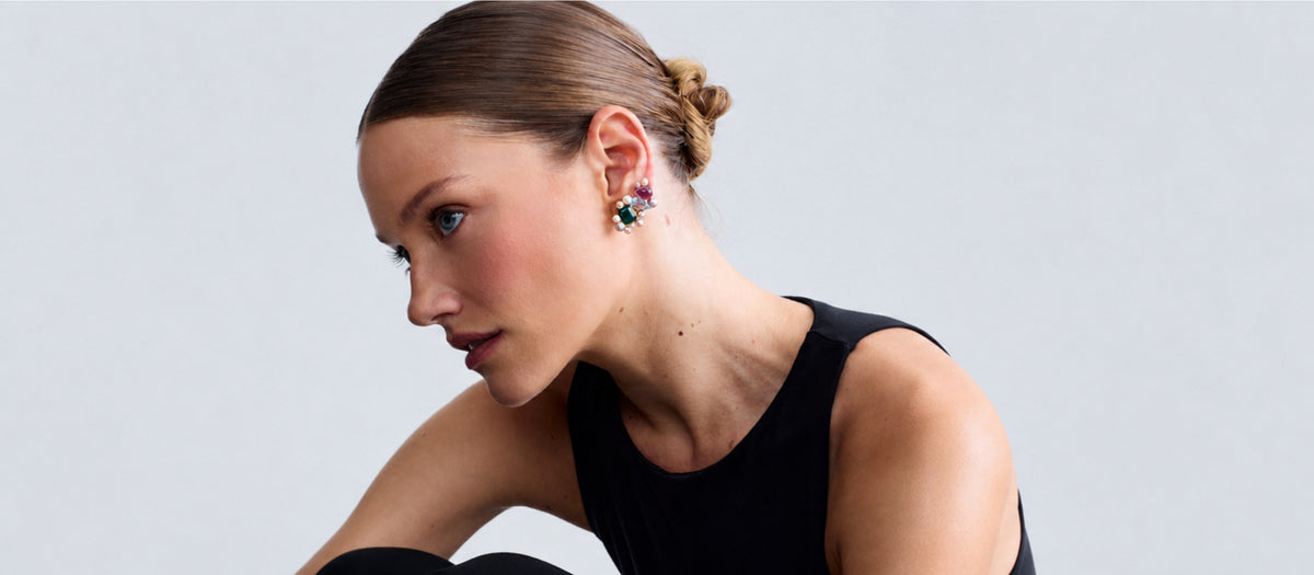 Fierce Pearls Artemisia Collector Earrings in 18K gold-plated finish worn by a model, featuring multicolored freshwater pearls, green agate, amethyst and blue topaz gemstones in an artistic statement jewelry design.