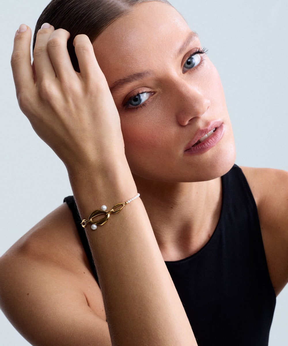 Editorial portrait of a model wearing the Audrey Swan Bracelet with white freshwater cultured pearls.