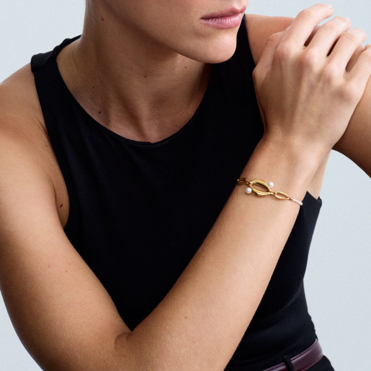 Close-up of a model wearing the Audrey Swan Bracelet in 18K gold-plated sterling silver featuring white freshwater cultured pearls.